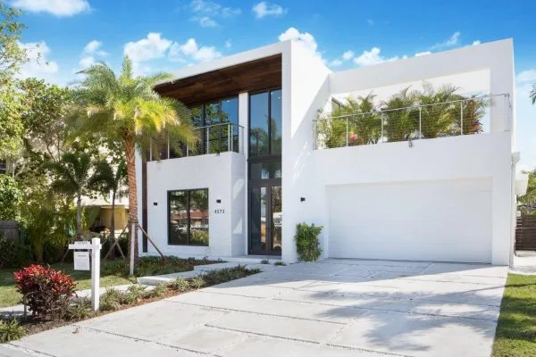 Front facade of modern two-story home with wood ceiling canopy and double balconies, Residential Architecture Miami Beach by Atelier International LLC
